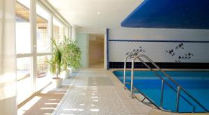 a swimming pool in a house with a blue wall at Landhotel Hubertus in Unterelsbach