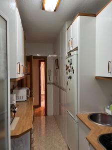 una cucina con armadietti bianchi e frigorifero di APARMENT LEGAZPI a Madrid