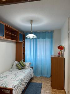 una camera con letto e tenda blu di APARMENT LEGAZPI a Madrid