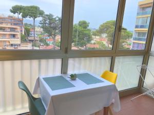 a white table and chairs in a room with windows at Coquet logement front de mer in Cagnes-sur-Mer