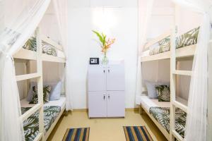 a room with three bunk beds in a room at BunkyDew in Galle