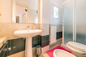 a bathroom with a sink and a toilet and a mirror at Case di Anna in Assisi