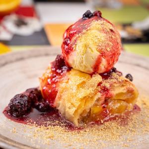 a plate with a piece of dessert with fruit on it at Hotel Lavina in Jahorina