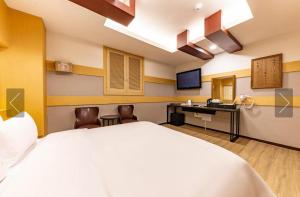 チョナンにあるCheonan Star Hotelの大きなベッドとデスクが備わるホテルルームです。
