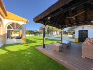 a wooden deck with a bench and a house at VILLA MACARENA in Espera