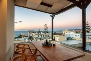 - une table en bois sur un balcon avec vue sur l'océan dans l'établissement Soleado apartment, à La Canée