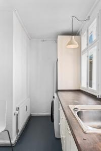 uma cozinha com um lavatório e uma bancada em Rooms in quiet white villa apartment Hortensiavej 8 on Frederiksberg C em Copenhague
