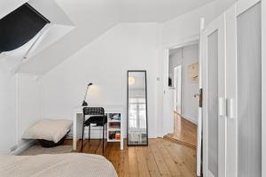 a white bedroom with a desk and a mirror at Rooms in quiet white villa apartment Hortensiavej 8 on Frederiksberg C in Copenhagen