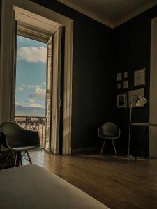 una camera con due sedie e una finestra con vista di Serendipity a Napoli