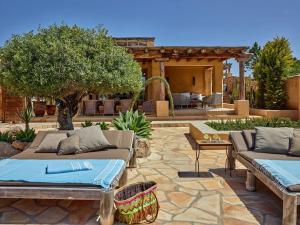 a patio with two couches and a tree in a yard at Kasbah 3 in Cala Vadella