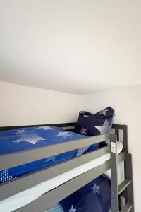 a bedroom with a bunk bed with blue sheets at Hausboot der Friesländer im Wangermeer in Wangerland