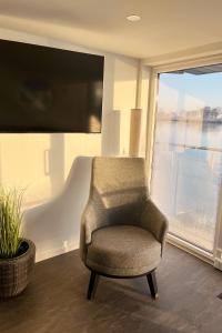 a chair in a room with a large window at Hausboot der Friesländer im Wangermeer in Wangerland