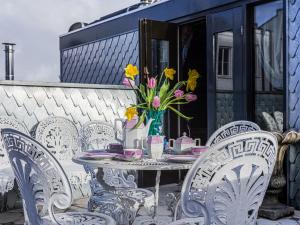 a table with chairs and a vase of flowers on a patio at Royal Suites - Salon de Franz in Amsterdam