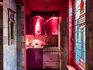 a red kitchen with pink cabinets and a stove at Royal Suites - Salon de Franz in Amsterdam +59 photos