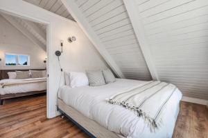 a white bedroom with two beds in a attic at Tidal House 5 in Ocean Shores