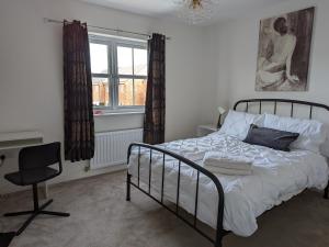 a bedroom with a bed and a chair and a window at Lovely 3 Bed Home for Colleagues in Darlington