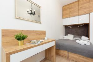 1 dormitorio con cama y escritorio de madera en Central Business District Warsaw Apartments by Renters en Varsovia