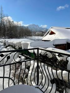a snow covered balcony with a metal railing with snow at Pokoje Gościnne Nowa Grań in Zakopane +56 photos