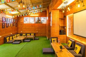 a conference room with tables and chairs and a projection screen at Lushtree Backpackers - Hostel & Cafe in Mukteswar