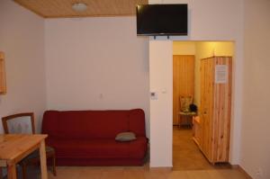 - un salon avec un canapé rouge et une télévision murale dans l'établissement Agroturystyka U Siwego, à Rokitki