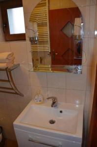 La salle de bains est pourvue d'un lavabo et d'un miroir. dans l'établissement Agroturystyka U Siwego, à Rokitki