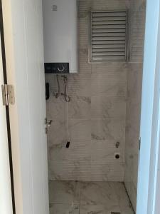 a bathroom with a shower with marble tiles at YALINCAK TERAS 1 SİTESİ in Cimenli