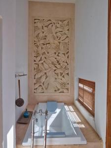 La salle de bains est pourvue d'une baignoire blanche et d'un mur en bois. dans l'établissement Kasbah 2, à San José