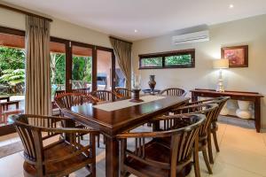 a dining room with a wooden table and chairs at San Lameer Villa 403 - 4 Bedroom Luxury - 8 pax - San Lameer Rental Agency in Southbroom