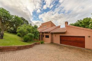 a house with a garage and a driveway at San Lameer Villa 403 - 4 Bedroom Luxury - 8 pax - San Lameer Rental Agency in Southbroom