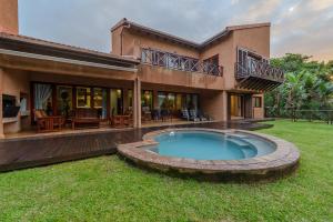 a house with a swimming pool in the yard at San Lameer Villa 403 - 4 Bedroom Luxury - 8 pax - San Lameer Rental Agency in Southbroom