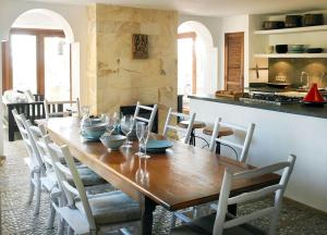 uma sala de jantar com uma mesa de madeira e cadeiras em Kasbah 2 em Sant Josep de sa Talaia