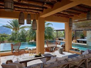 an outdoor living room with a pool and chairs at Kasbah 2 in Sant Josep de Sa Talaia