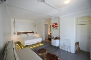 een woonkamer met een bed en een bank bij Flaskos Suites and more in Agios Stefanos