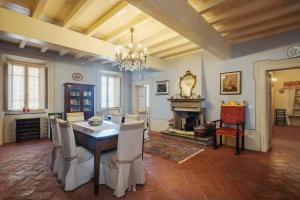 a dining room with a table and chairs and a fireplace at Villa Melangola in Camaiore