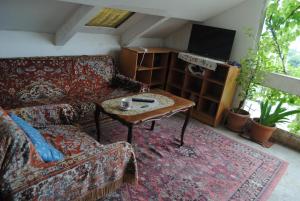 ein Wohnzimmer mit einem Sofa und einem Tisch in der Unterkunft Family Guesthouse - MACHARASHVILI in Tbilisi City