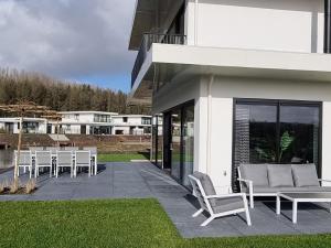 a group of chairs and tables on a patio at Nice water villa near forest, golf course and Veluwemeer in Zeewolde