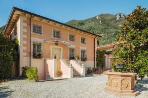 a large house with a driveway and mountains in the background at Villa Melangola in Camaiore