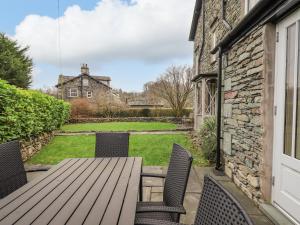 a patio with a wooden table and chairs at Honeywood House in Grasmere