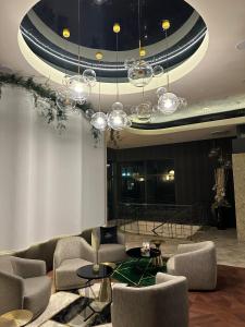 a lobby with chairs and tables and a chandelier at Hotel Falko in Rumia