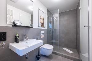 La salle de bains est pourvue d'un lavabo, de toilettes et d'une douche. dans l'établissement limehome Stuttgart Elsenhansstr, à Stuttgart