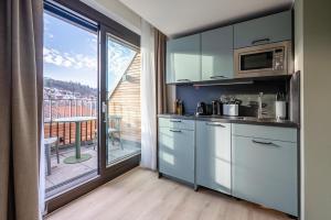 a kitchen with stainless steel appliances and a balcony at limehome Stuttgart Elsenhansstr in Stuttgart