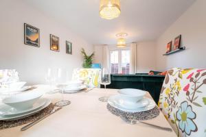 a dining room with a table with plates and wine glasses at Brookfield in Horley