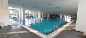 a large swimming pool with blue water in a building at stylish flat-eagle eye for istanbul in Istanbul
