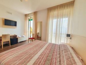 a bedroom with a bed and a desk and a window at Casa Immacolata in Verbania