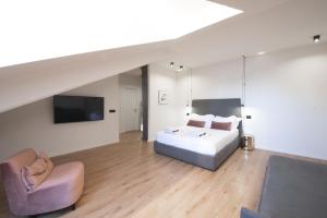 een slaapkamer met een bed, een bank en een tv bij San Carlo Suite Torino in Turijn