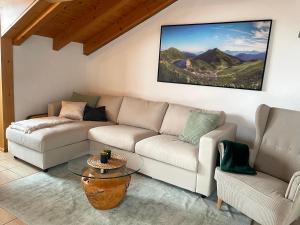 uma sala de estar com um sofá e uma mesa em Landhaus Obermaiselstein "THE VIEW" em Obermaiselstein