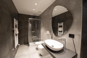 a bathroom with a sink and a toilet and a mirror at San Carlo Suite Torino in Turin