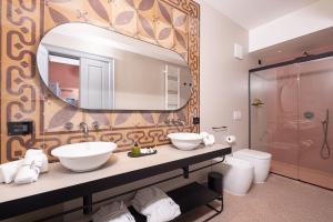a bathroom with two sinks and a mirror at VIS Urban Suites&Spa in Bari