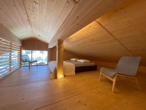 ein Schlafzimmer mit einem Bett und einem Stuhl in einem Zimmer in der Unterkunft Horizon 4 in Schwarzsee