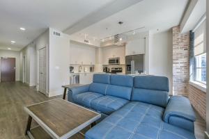 a living room with a blue couch and a table at Captivating Condo near City Hot Spots in New Orleans